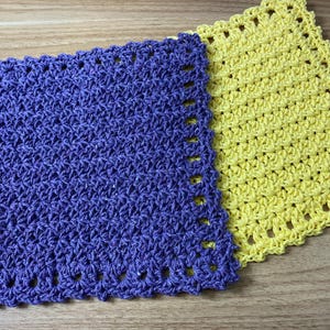 May include: Two crocheted dishcloths, one purple and one yellow. Both dishcloths have a scalloped edge.