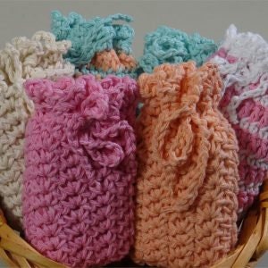 May include: A basket containing six crocheted drawstring bags in a range of pastel colours, including pink, peach, white and blue.