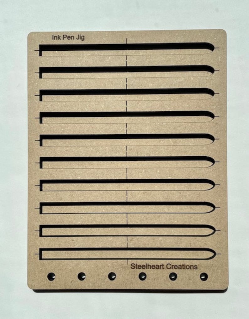 May include: A wooden jig with the text "Ink Pen Jig" and "Steelheart Creations" printed on it. The jig has 10 slots for holding ink pens.