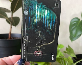 May include: A black card with a forest scene and a key symbol. The card has the word "DISTILL" printed vertically on the left side and the number "42" printed in the top right corner.