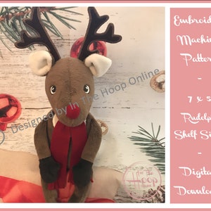 May include: Embroidery machine pattern for a 7x5 inch Rudolph shelf sitter. The pattern is a digital download. The image shows a brown plush Rudolph reindeer with a red scarf, sitting on a white surface.