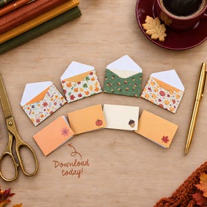 Op de afbeelding: Een verzameling miniatuurenveloppen en gevouwen kaarten met herfstpatronen van bladeren, pompoenen en eikels. De set bevat vier open enveloppen en vier gesloten kaarten, vergezeld door een gouden schaar, een gouden pen en de tekst Download today!