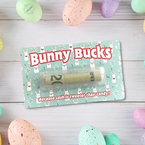 May include: A gift card holder with the text "Bunny Bucks" and a rolled-up twenty-dollar bill. The card has a light blue background with a bunny pattern and the phrase "Because cash is sweeter than candy!" Easter eggs surround the card.