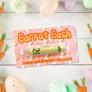 May include: A pink card with the words "Carrot Cash" in orange lettering, featuring a rolled-up bill. The card has a repeating pattern of white bunnies and carrots. The text "Because cash is sweeter than candy!" is also on the card.