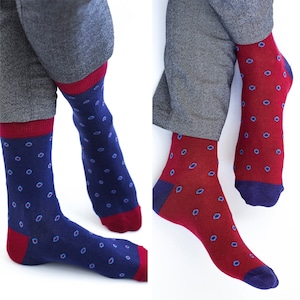 May include: Two pairs of socks with a red and blue geometric pattern. One pair is blue with red dots and the other is red with blue dots.