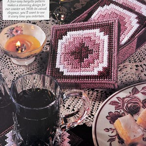 May include: A set of four pink and white bargello coasters. The coasters are made with a four-way bargello pattern and are perfect for adding a touch of elegance to any home.