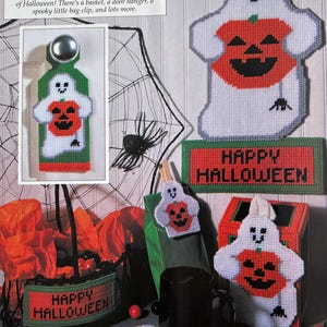 Könnte beinhalten: Ein Set an Halloween-Handarbeiten mit Geistern, die Kürbisse halten. Das Set beinhaltet einen Türkranz, einen Korb, einen Taschentuchbox-Überzug, einen Becherwärmer und einen Beutelverschluss. Die Handarbeiten sind alle aus weißem Filz gefertigt und zeigen orangefarbene Kürbisse mit schwarzen Kürbisgesichtern. Der Text "Happy Halloween" ist auf dem Korb und dem Taschentuchbox-Überzug zu sehen.