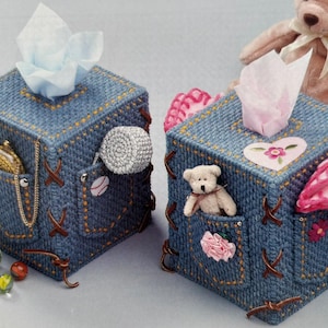 May include: Two denim-style tissue box covers with pockets and decorative stitching. One has a baseball and a crocheted ball, the other a teddy bear and a pink flower. Both have tissue coming out of the top.