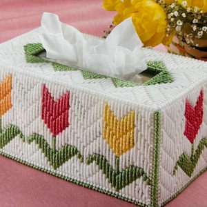 May include: White tissue box cover with a green and white diamond pattern. The cover features embroidered tulips in yellow, red, and orange.