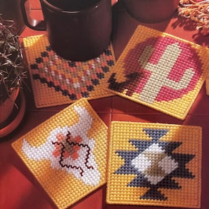 May include: Four square yellow coasters with different colorful designs. The designs include a cactus, a bull skull, a geometric pattern, and a southwestern pattern.