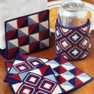 May include: Four red, white, and blue crocheted coasters with a geometric pattern. A matching crocheted napkin holder with a stack of white napkins. A crocheted can cooler with the same geometric pattern.