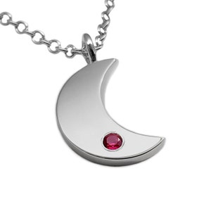 May include: A silver crescent moon pendant necklace with a small red gemstone in the center.