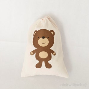 May include: A small, white cotton drawstring bag with a brown bear illustration. The bear has a brown nose, brown eyes, and a light brown belly.