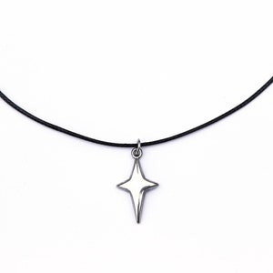 Puede incluir: Un collar sencillo con un colgante de estrella plateada en un cordón negro.