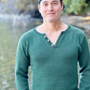 May include: A green long-sleeved sweater with a buttoned v-neck.