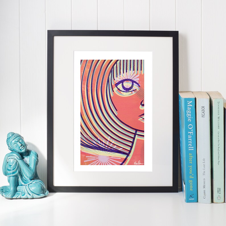 May include: A framed print of a colorful abstract portrait of a person with a striped hairstyle. The print is in a black frame and is sitting on a white surface.