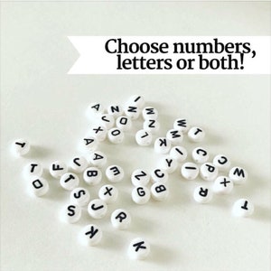 May include: White round beads with black letters and numbers. The beads spell out the words "Choose numbers, letters or both!"