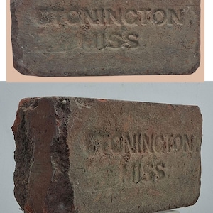 Könnte beinhalten: Ein verwitterter Ziegelstein mit dem geprägten Text "STONINGTON, MASS". Der Ziegelstein hat eine rotbraune Farbe mit sichtbaren Gebrauchsspuren, die auf Alter und Nutzung hindeuten. Der Text ist leicht verblasst.