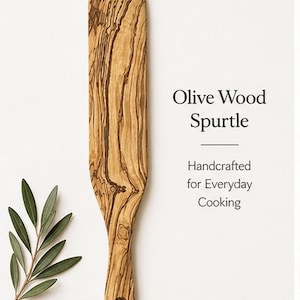 May include: An olive wood spurtle with a long, flat design, featuring a natural wood grain pattern. The text "Olive Wood Spurtle" and "Handcrafted for Everyday Cooking" are displayed. A sprig of olive leaves is also present.