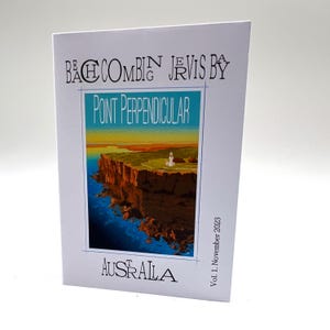 May include: A white booklet with the text "Beachcombing Jervis Bay" and "Point Perpendicular" in blue and green. The cover features a landscape illustration of a cliffside with a lighthouse. The word "Australia" is printed at the bottom, with "Vol. 1. November 2023" on the right.