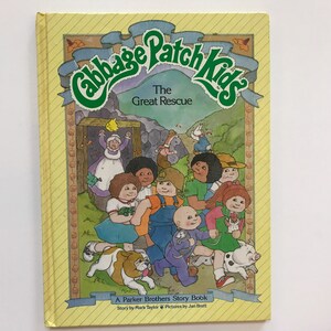May include: A yellow book cover with the title "Cabbage Patch Kids The Great Rescue" in green letters. The cover features an illustration of a group of Cabbage Patch Kids characters, including a dog and a pig.