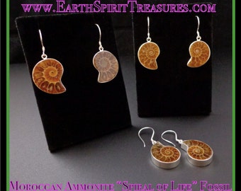 May include: Earrings featuring Moroccan ammonite fossils. The earrings display a spiral design in shades of brown and tan, set in silver. The image includes the text "WWW.EarthSpiritTreasures.com" and "Moroccan Ammonite 'Spiral of Life' Fossil".
