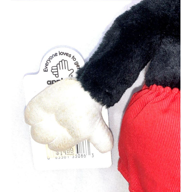 May include: A plush black and red Mickey Mouse toy with a white glove. The toy is holding a thumbs down gesture. The toy has a tag that says "Everyone loves to get along" and has a price tag of $14.99.
