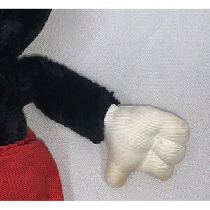 Puede incluir: Un juguete de peluche negro y rojo con un guante blanco. El juguete es un personaje de dibujos animados cl&aacute;sico.