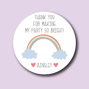 May include: Round white thank you sticker with a rainbow, clouds, and the text "Thank you for making my party so bright! Ainsley".