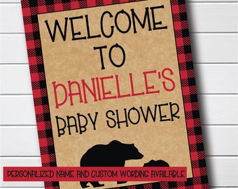 Puede incluir: Bienvenido a la fiesta de bienvenida al bebé de Danielle con un borde de cuadros rojos y negros y una silueta de una mamá oso y un cachorro. El cartel está impreso en papel marrón.