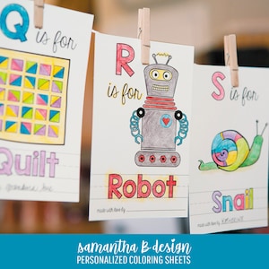 May include: Three white paper coloring sheets hanging from wooden clothespins. The sheets feature the letters Q, R, and S with illustrations of a quilt, a robot, and a snail. Each sheet includes the text is for and a blank line for a name.