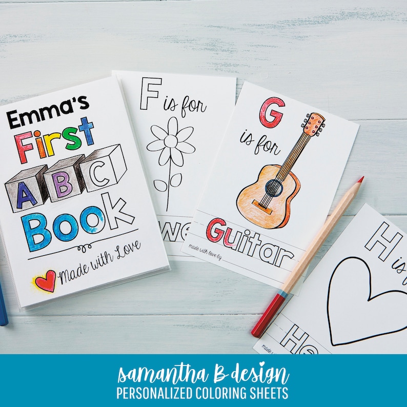 May include: A personalized coloring book titled Emma's First ABC Book with a red heart icon, alongside individual coloring sheets featuring the letters F, G, and H with illustrations of a flower, a guitar, and a heart, plus a colored pencil.