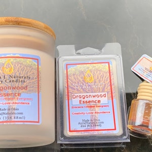 Puede incluir: Tres productos Dragonwood Essence: una vela de soja de 354 ml, una cera fundida de 60 ml y un ambientador de coche. Todos los productos presentan una etiqueta con un diseño de árbol y el texto "Dragonwood Essence" y "Creatividad-Amor-Abundancia".