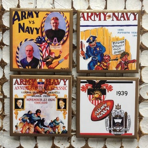 May include: Four vintage-style coasters featuring the Army vs. Navy rivalry. Each coaster has a different design, including a football game, a cartoon of a sailor and a soldier, and a crest with the words "Army Navy".