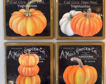 May include: A set of four square coasters featuring vintage-style advertisements for Henry Musser and A. Moll Grocer Co. Each coaster displays colorful illustrations of orange and white pumpkins against a dark background with printed text.