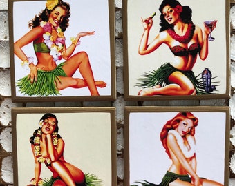 Op de afbeelding: Set van vier vierkante onderzetters met vintage illustraties van vrouwen in hula-rokken en tropische bloemen. De onderzetters hebben een gouden rand en een witte achtergrond.