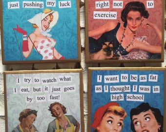 Puede incluir: Cuatro posavasos de estilo vintage con refranes humorísticos sobre el ejercicio y el peso. Cada posavasos presenta una imagen diferente de una mujer de la década de 1950. Los refranes en los posavasos son: "Hago suficiente ejercicio simplemente empujando mi suerte", "Estoy haciendo ejercicio, pero no para hacer ejercicio", "Intento vigilar lo que como, ¡pero se va demasiado rápido!" y "Quiero ser tan gorda como pensaba que era en la escuela secundaria".