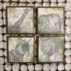 May include: Set of four square coasters featuring black and white line drawings of a giraffe, elephant, zebra, and lion on a beige background with a green border.