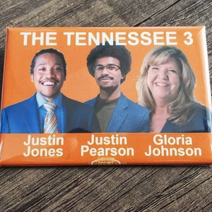 May include: Rectangular orange button featuring three smiling people with the text "THE TENNESSEE 3" at the top. Below are the names Justin Jones, Justin Pearson, and Gloria Johnson.