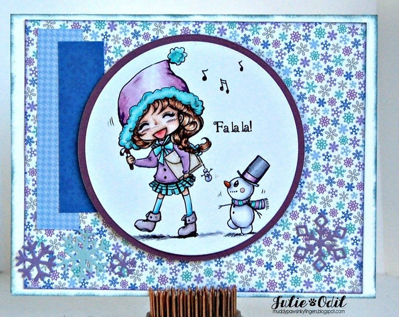 May include: A purple-clad girl with a blue hat sings "Fa la la!" to a snowman with a top hat and scarf against a background of blue and purple snowflakes.
