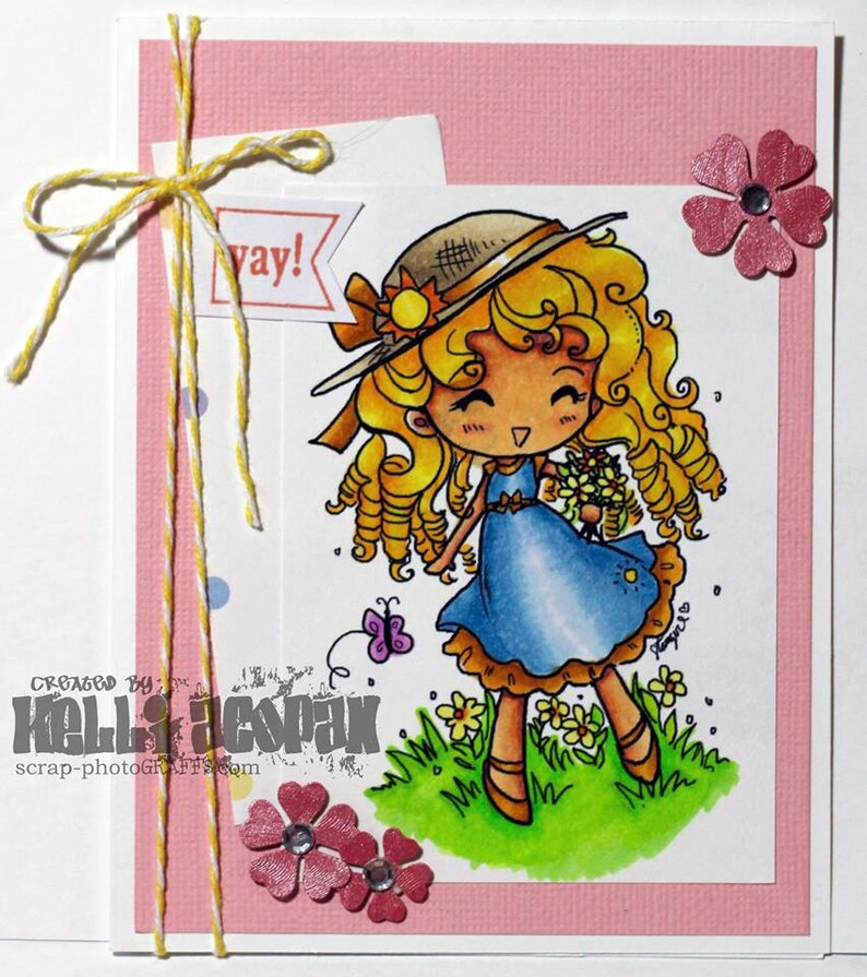 May include: A pink card with a yellow and white twine bow. The card features a cartoon illustration of a girl with blonde curly hair wearing a blue dress and a straw hat. The girl is holding a bouquet of flowers. The text "yay!" is on a white banner. The card is decorated with pink flowers.