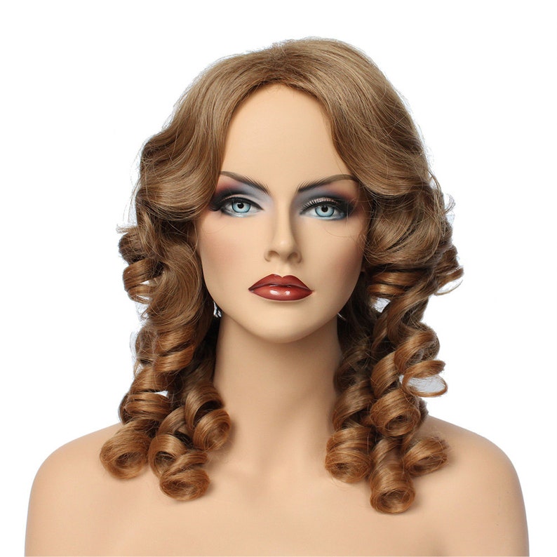 May include: A brown wig with long, curled hair styled in two large ringlets on either side of the head. The wig is on a mannequin head with a neutral makeup look.