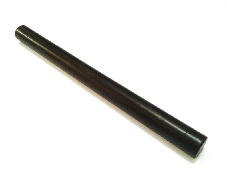 May include: A dark brown, cylindrical wooden dowel rod. The rod is straight with a smooth, polished surface and rounded ends. The dowel is set against a white background.