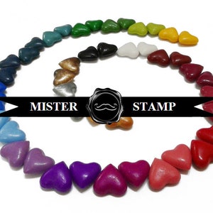May include: A rainbow of heart-shaped wax seals arranged in a spiral pattern. The wax seals are in various colors, including red, orange, yellow, green, blue, purple, and brown. The text "MISTER STAMP" is printed on a black ribbon.