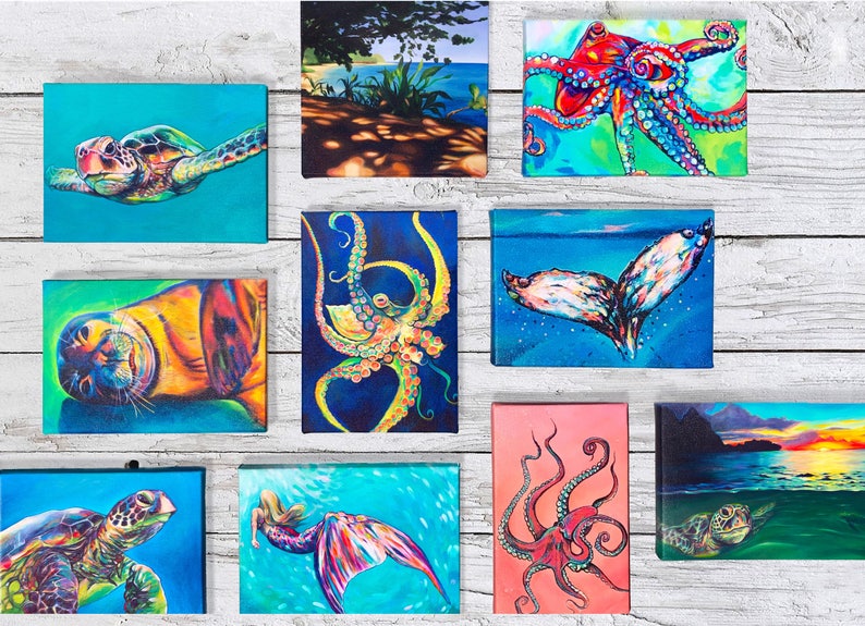 May include: A collection of 10 colorful paintings featuring various sea creatures, including a turtle, octopus, whale tail, seal, and mermaid. The paintings are displayed on a white wooden background.