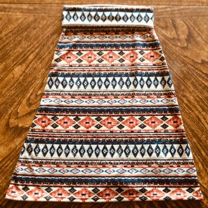 May include: A white, blue, and red patterned skirt with a geometric design. The skirt is made of a soft, stretchy fabric and has a comfortable fit.