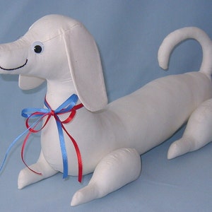 May include: White fabric dachshund dog plush toy with blue and red ribbon bow.