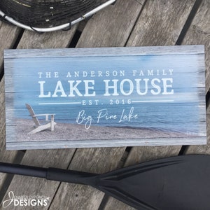 Outdoor lake house sign featuring a photo of the lake shore and personalized with your family name, established date and location.
