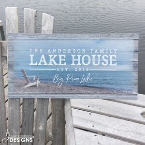Outdoor lake house sign featuring a photo of the lake shore and personalized with your family name, established date and location.
