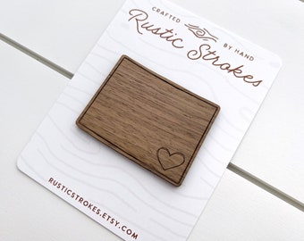 May include: A wooden sign with a heart carved into it. The sign is made of walnut wood and has a rustic finish. The sign is crafted by hand and is perfect for adding a touch of rustic charm to your home decor.